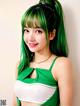 A woman with green hair wearing a green and white top.